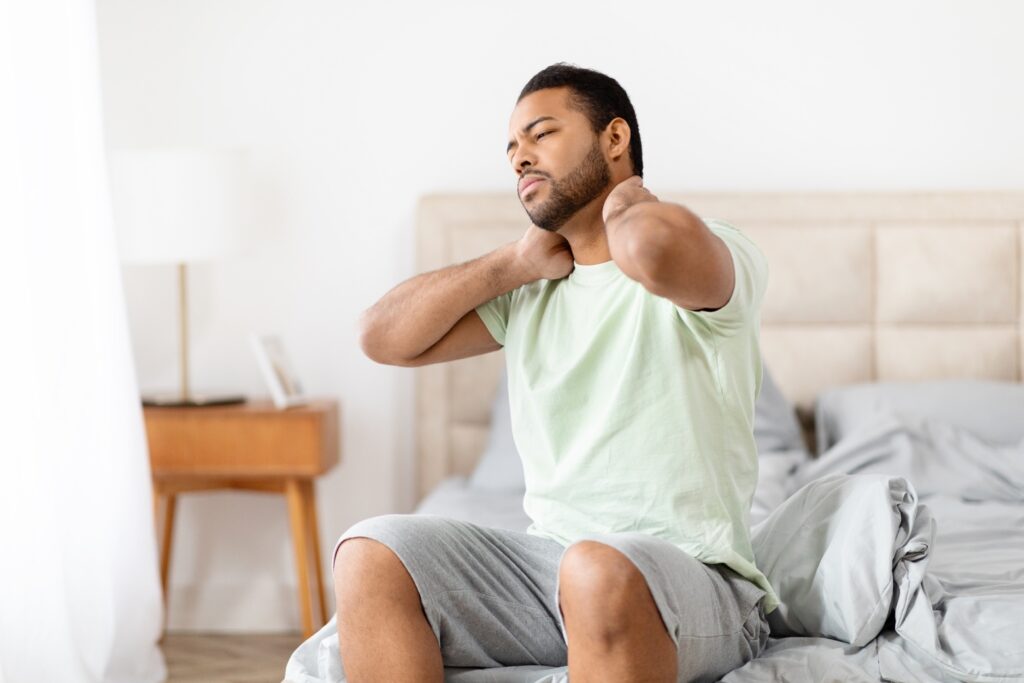 Efectos secundarios de la terapia CAR-T: Hombre experimentando dolor de cuello, un posible efecto secundario de la terapia CAR-T. Es importante conocer los posibles efectos secundarios del tratamiento.