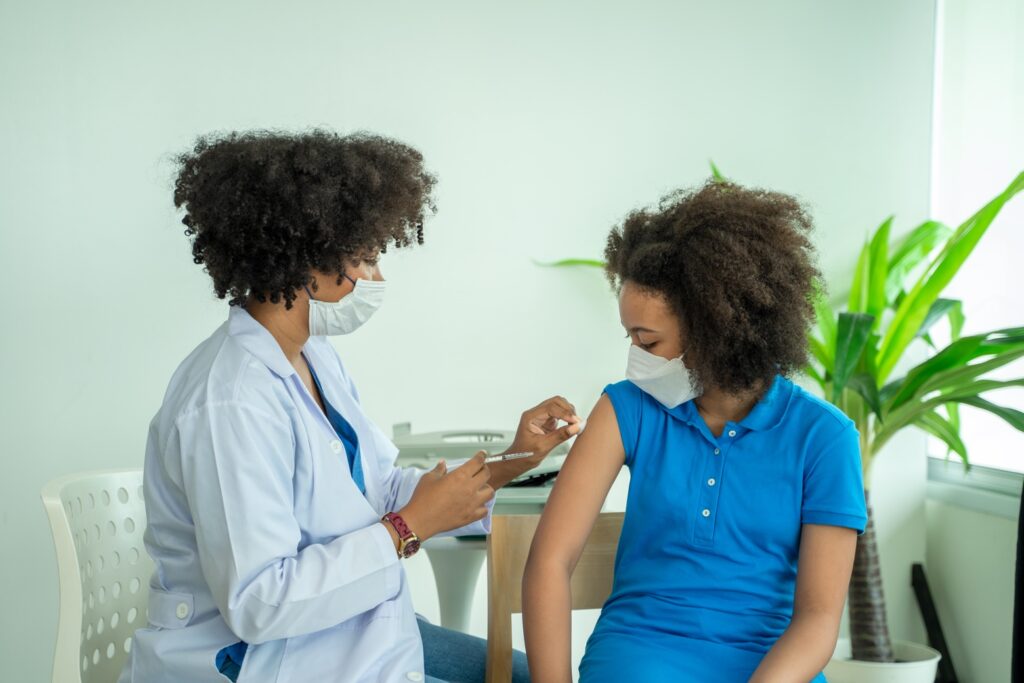 Una enfermera administra la vacuna contra el VPH a un adolescente. Resaltando la importancia de la vacunación para prevenir la infección por VPH.