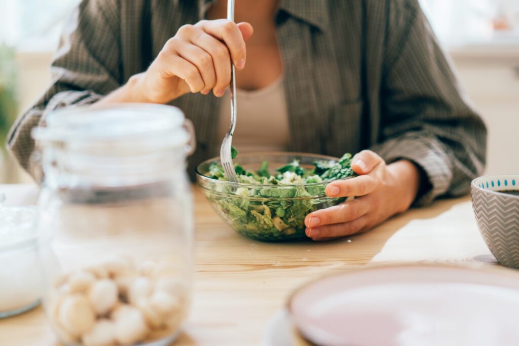 Una mujer come una ensalada saludable de verduras verdes