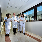 Estancias formativas. Estudiantes de medicina caminando por un pasillo con un médico.