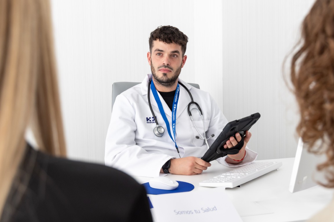 Medico con pacientes en su consulta