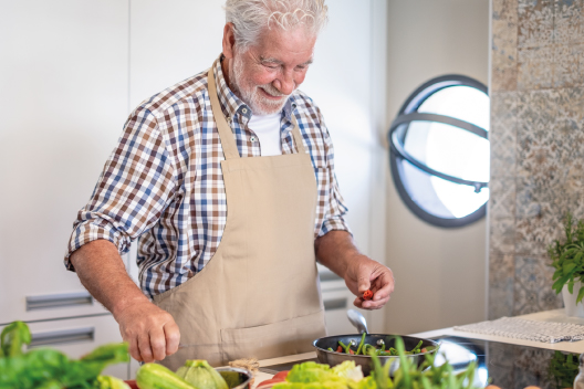 Señor de avanzada edad cocinando comida saludable