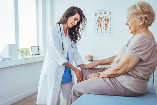 Señora mayor en consulta médica con dolor de rodilla