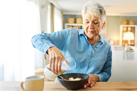 Señora de 70 años desayunando lacteos y cereales