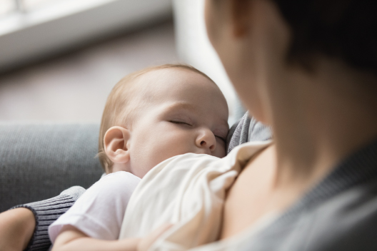 Bebé lactando en los brazos de su madre