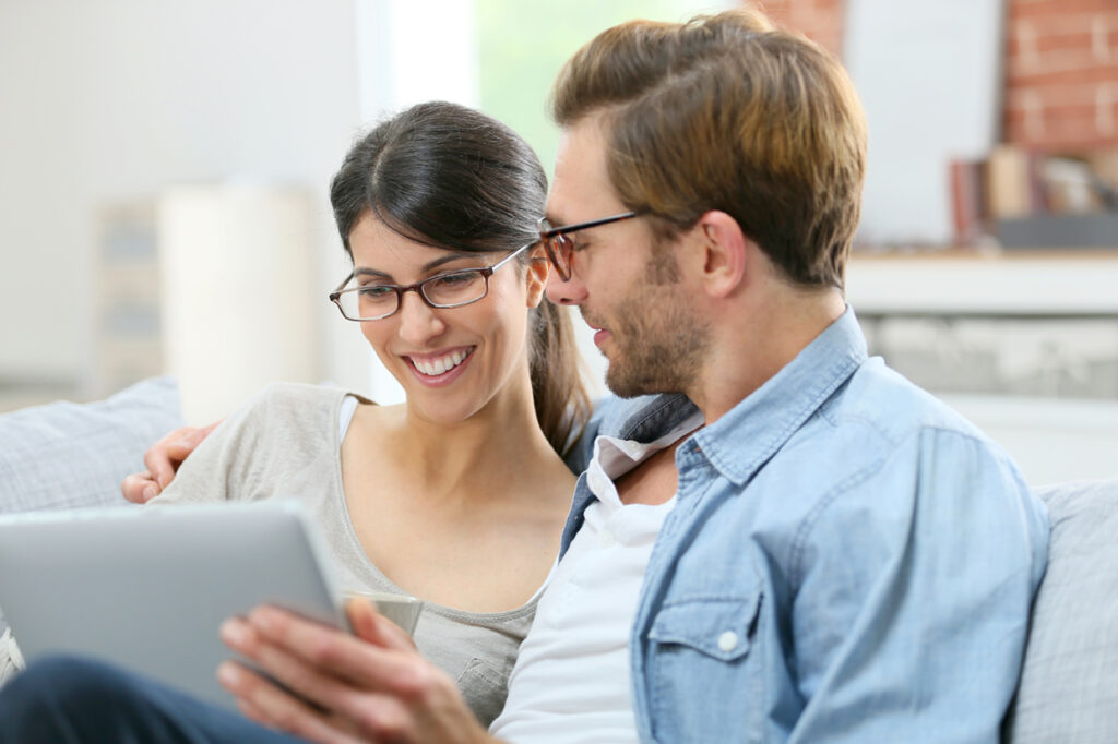 Pareja en su casa con una tablet en la mano