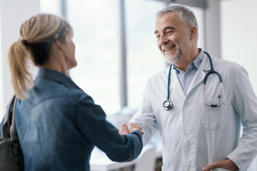 Doctor saludando a una paciente tras la consulta