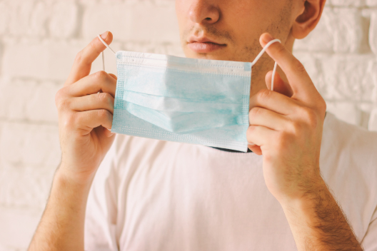 Chico de 28 años colocándose una mascarilla