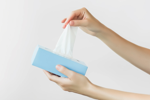 Manos agarrando pañuelos de papel