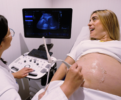 Foto de médico y mujer embarazada realizando ecografía