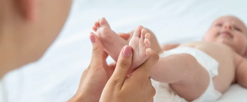 Manos de una madre sosteniendo los pies de un bebé recien nacido