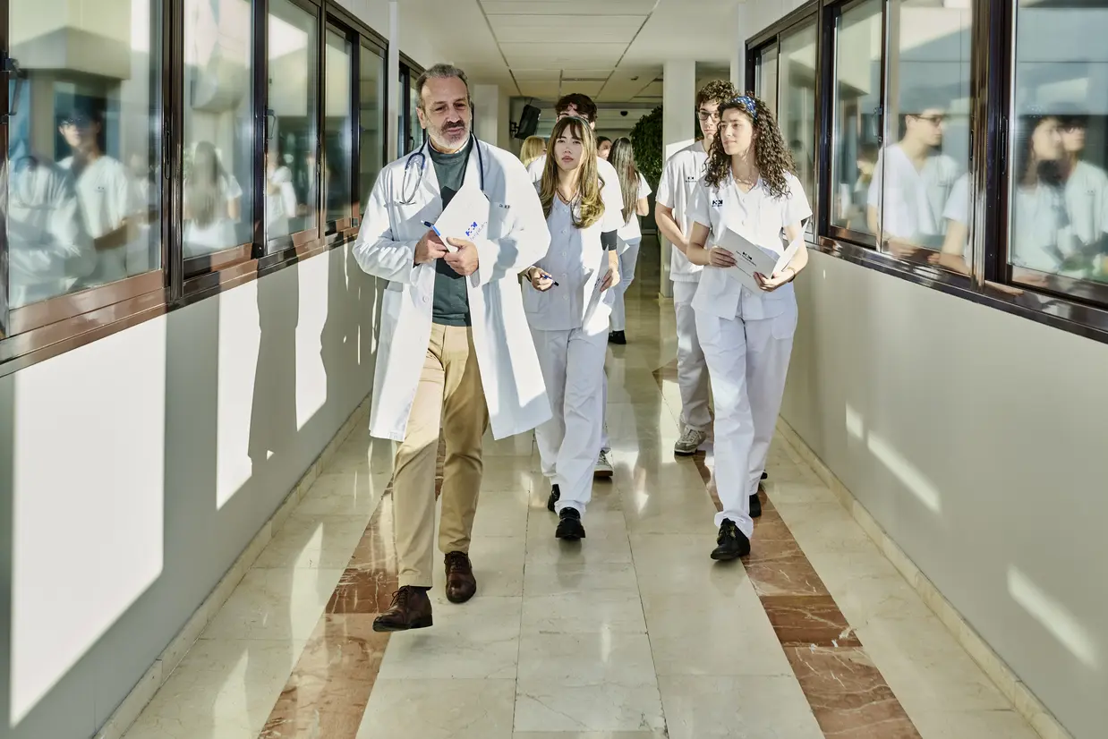 Cuhmed - Medico y estudiantes andando en un pasillo