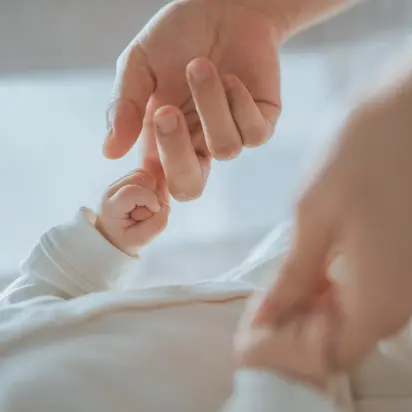 Mama sosteniendo las manos de su bebe