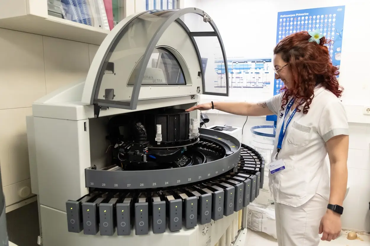 Personal sanitario trabajando en una máquina de análisis de laboratorio.